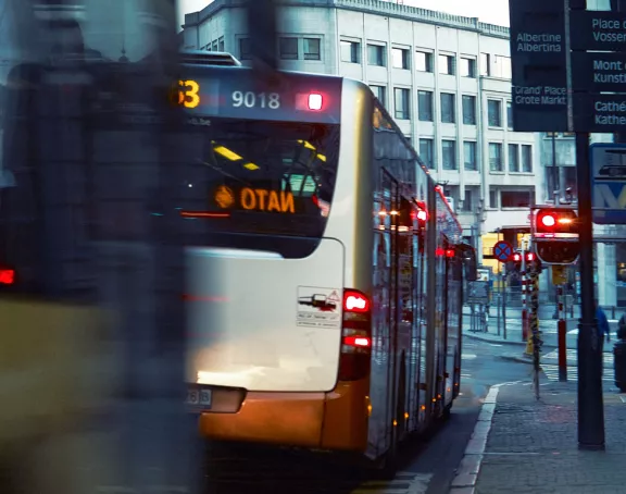  Close-up image capturing the motion of buses navigating a lively street in Brussels