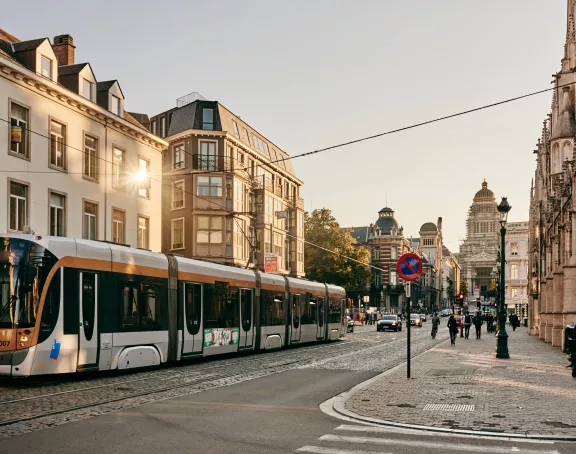 Tram gliding down the picturesque Rue de Régence in Brussels, surrounded by historic architecture and cobblestone streets