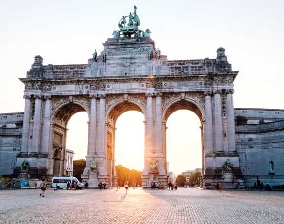 Triumphal Arch at Cinquantenaire Park, with sunlight shining through the three arches