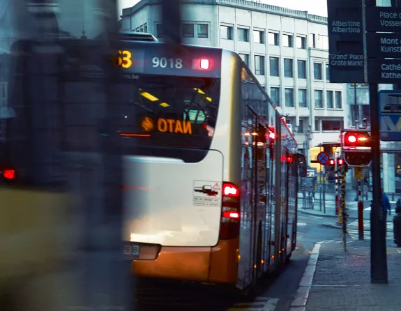  Close-up image capturing the motion of buses navigating a lively street in Brussels