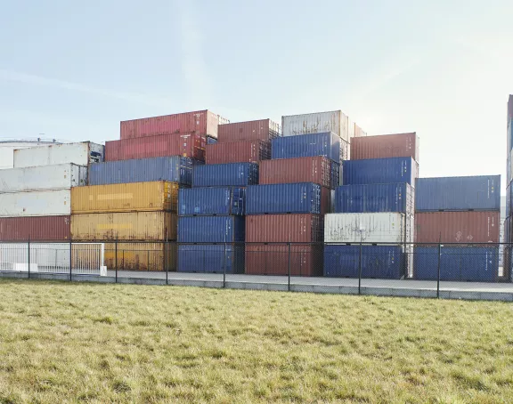 Truck driving past storage tanks and containers in the Port of Antwerp