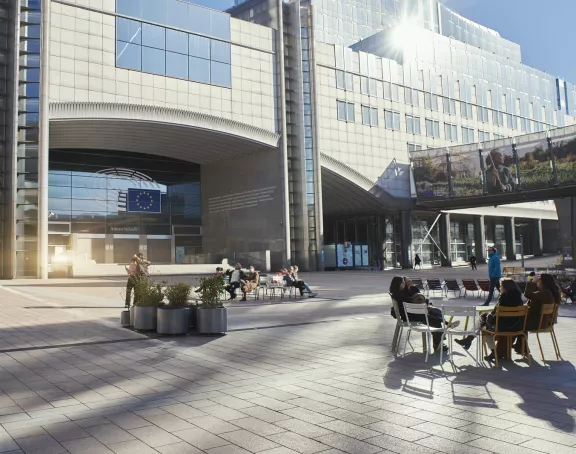 People sitting together and socializing in front of the European Parliament in Brussels