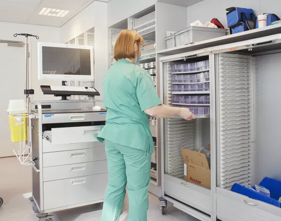 Nurse in uniform working in a hospital storage room 
