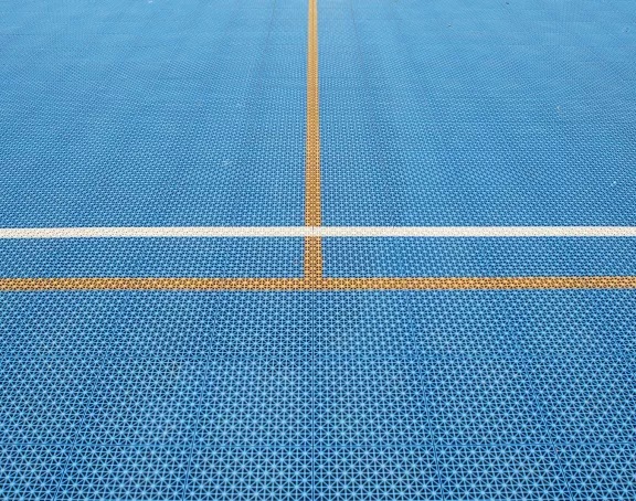 Close-up of crossed yellow and white floor markings in an indoor sports hall