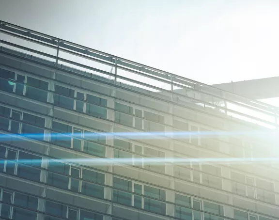 Cropped image of the top of a glass building bathing in radiant sunlight