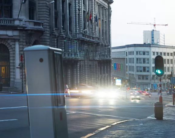 Brussels street at dusk with cars in motion, headlights lighting up the surroundings