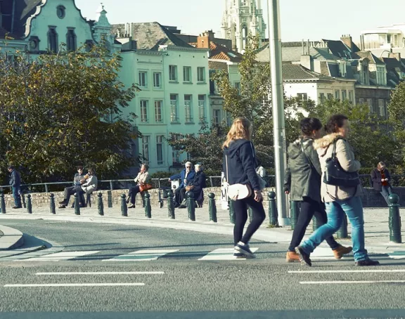 Lively square in Brussels filled with pedestrians and people soaking up the sun