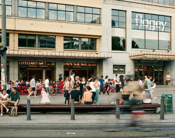 Flagey Square in Brussels bustling with people strolling, chatting and relaxing at cafes