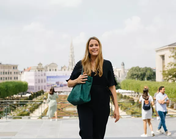 Female Stibbe lawyer smiling at the camera while walking up the steps at Mont des Arts in Brussels