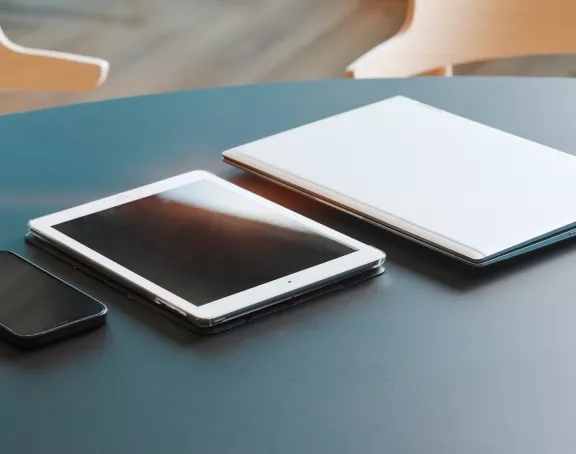 Office table with a phone, tablet and laptop