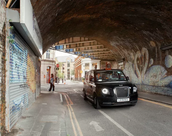 London black cab in a tunnel with graffiti