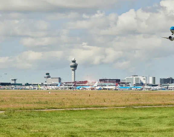 Airplane in the sky with the skyline of Schiphol Airport 