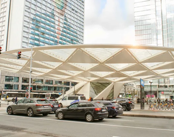 Place Rogier in Brussels bustling with crowds and traffic against a backdrop of tall buildings.