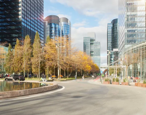 Roundabout in Brussels with glass skyscrapers in the background, surrounded by pedestrians and cars.
