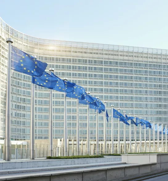 European flags waving in front of the European Parliament in Brussels