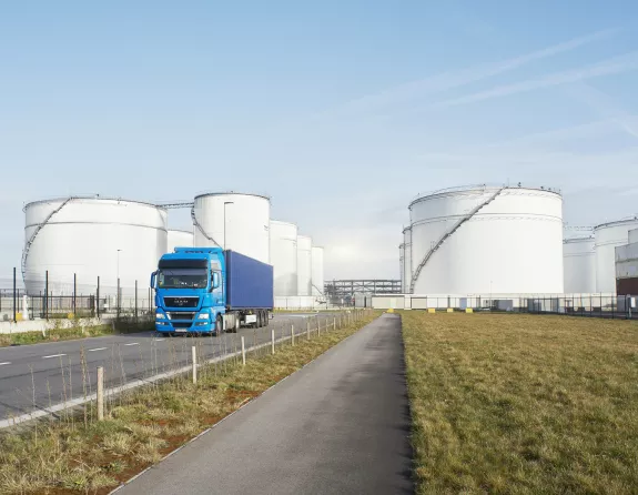 Truck driving away from storage tanks and containers in the Port of Antwerp