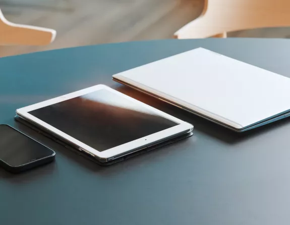 Office table with a phone, tablet and laptop