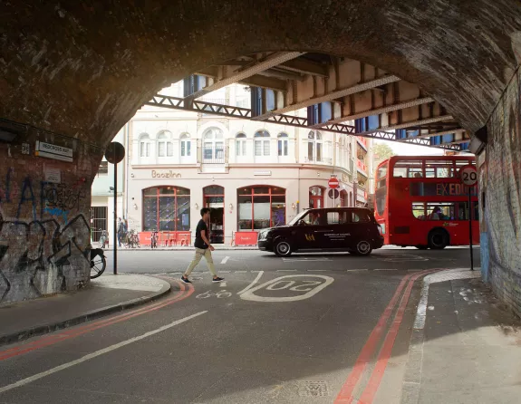 London black cab and double decker bus from a tunnel with graffiti