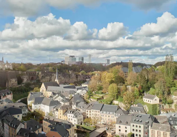 Panoramic view of Grund in Luxembourg City, showcasing a picturesque scene with historic buildings and lush greenery