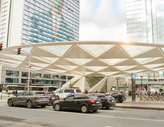 Place Rogier in Brussels bustling with crowds and traffic against a backdrop of tall buildings.